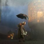 old women walking with umbrella and bucket in hand