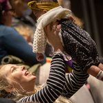 A woman lifting a baby and having fun at our Family Fun Day.