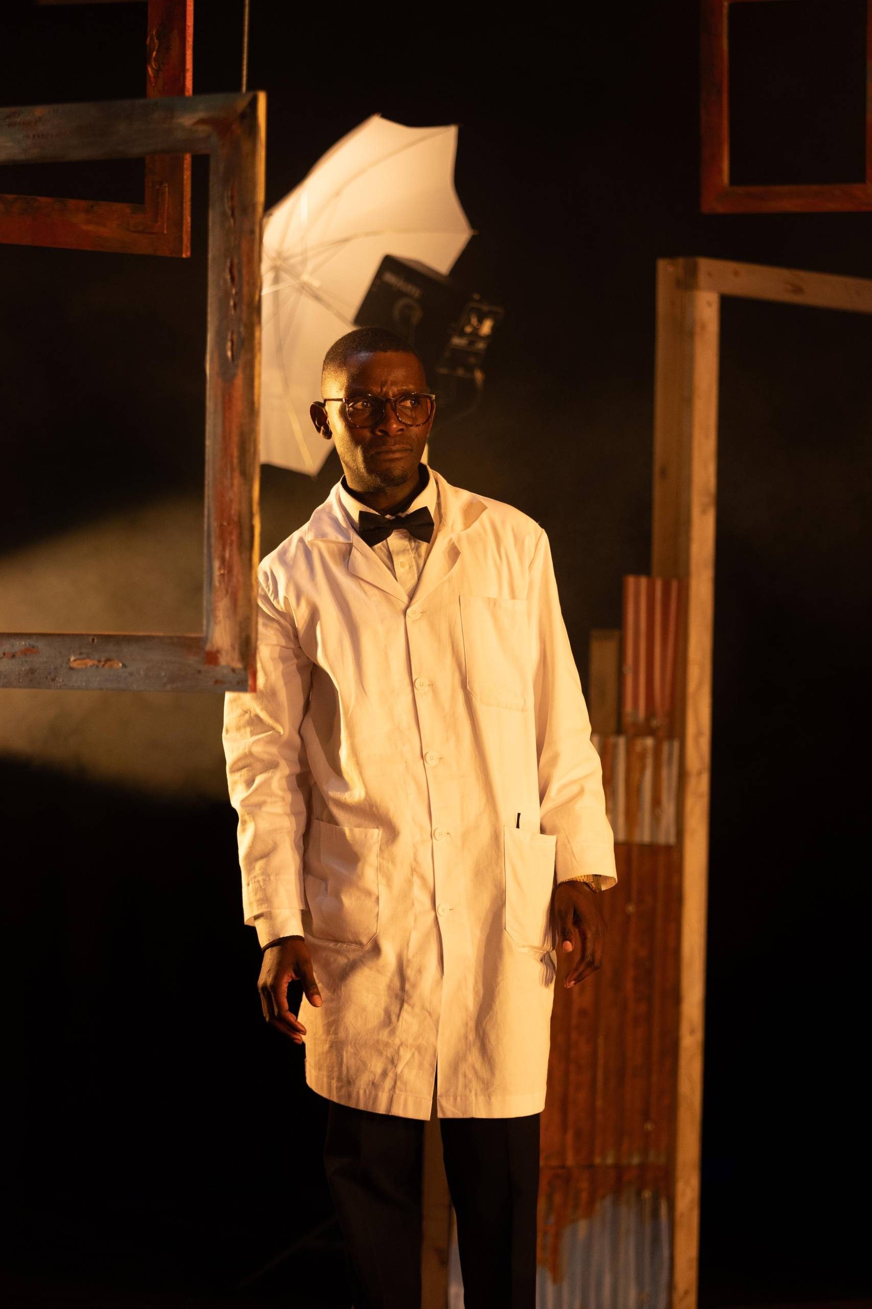 One male character wearing a lab coat and bow tie looks into the distance with confusion and shock in his face.