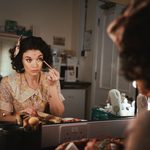 Katie Tonkinson applies eye make-up in a dressing room mirror