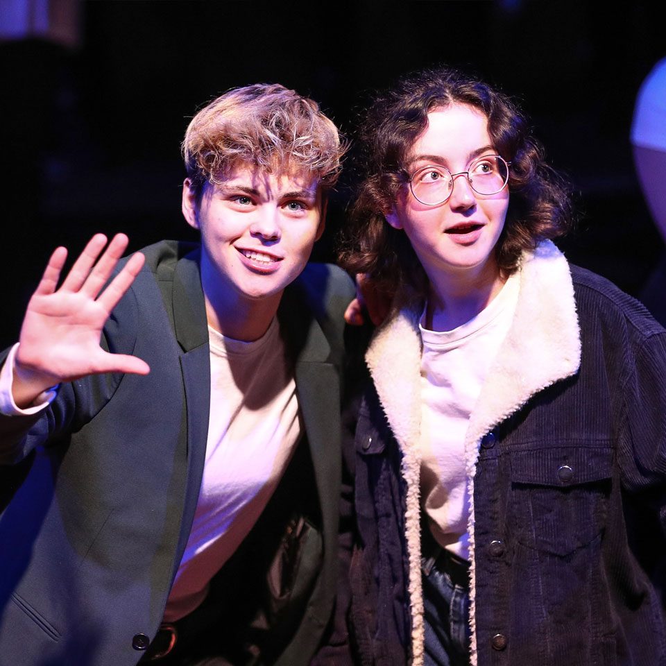 close-up image of 2 actors from Mayflower Youth Theatre staring in awe during a scene of Rise and Bloom.